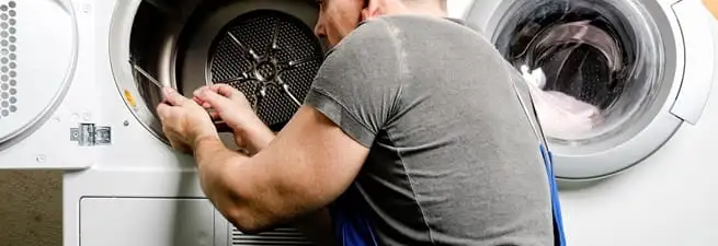 Dryer repair technician fixing a clothes dryer drum in Peoria, IL