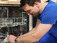 Dishwasher repair technician inspecting and servicing an open dishwasher in Peoria, IL