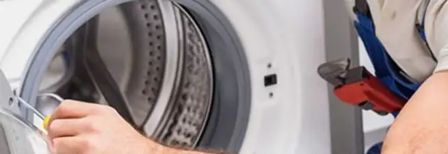 Appliance technician repairing a clothes dryer drum and internal parts in Peoria, IL