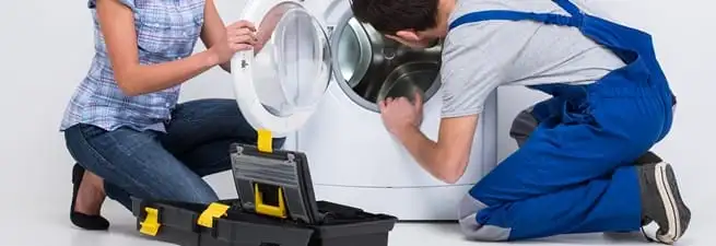 Washer repair technician inspecting a front-load washing machine with tools in Peoria, IL