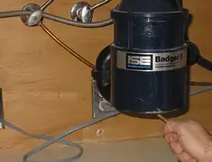 Garbage disposal repair technician tightening the mounting ring under a sink in Peoria, IL