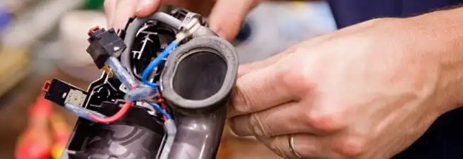 Vacuum repair technician reconnecting wiring and components in Peoria, IL