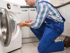Washing machine repair technician servicing a front-load washer in Peoria, IL